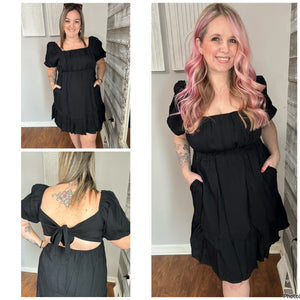 Black mini babydoll dress with tie back details and pockets