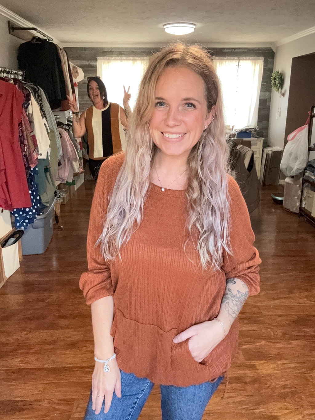 Rust top with kangaroo pocket and drawstring hem detail. S